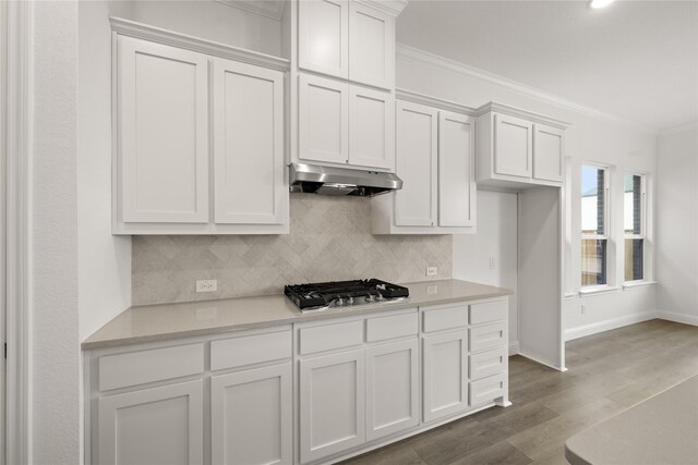 kitchen featuring dark hardwood / wood-style flooring, white cabinetry, stainless steel gas stovetop, and ornamental molding