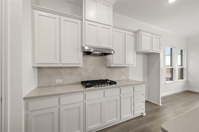 kitchen featuring dark wood-type flooring, ornamental molding, stainless steel gas cooktop, and white cabinets