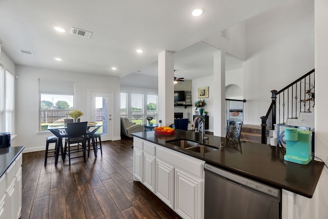 kitchen featuring sink, dark wood-type flooring, dishwasher, plenty of natural light, and white cabinets