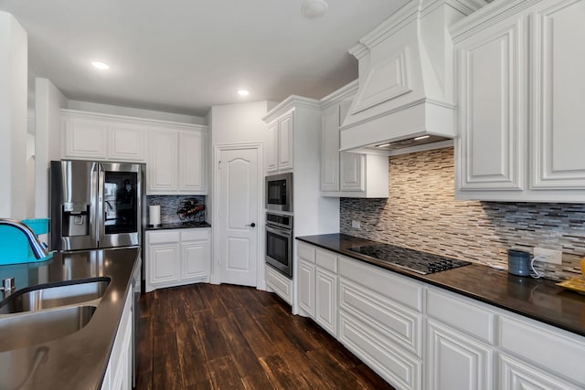 kitchen with white cabinetry, appliances with stainless steel finishes, tasteful backsplash, and custom range hood