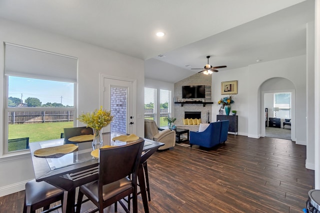 dining space featuring ceiling fan, a large fireplace, lofted ceiling, and wood-type flooring