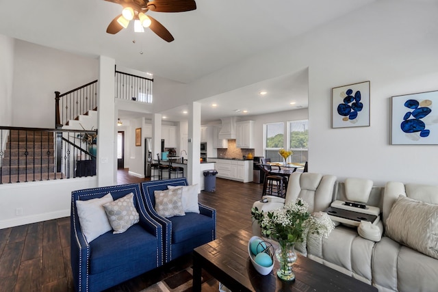 living room with ceiling fan and dark hardwood / wood-style flooring