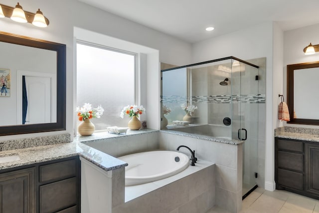 bathroom with tile patterned flooring, independent shower and bath, and vanity