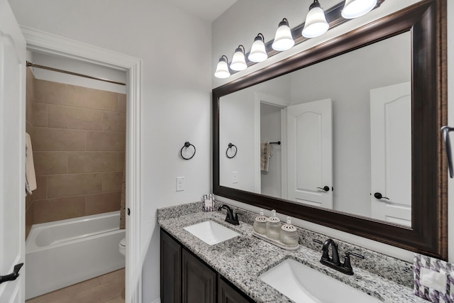 full bathroom with toilet, tiled shower / bath combo, and dual bowl vanity