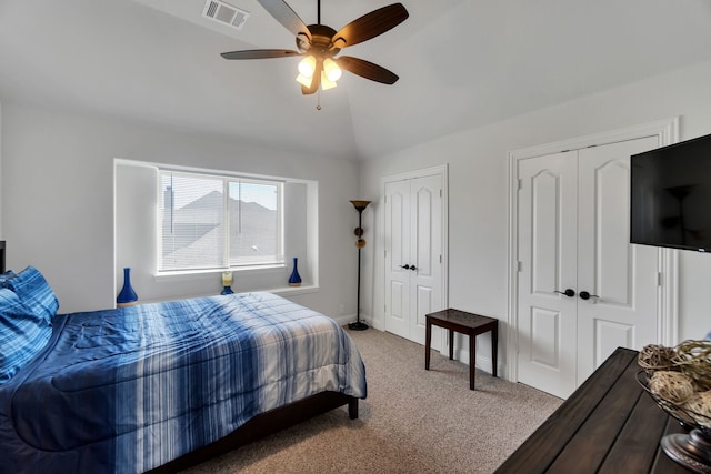 bedroom featuring ceiling fan, carpet, two closets, and lofted ceiling