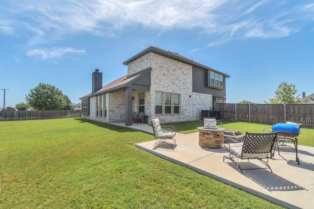 back of house featuring a lawn, a patio, and a fire pit