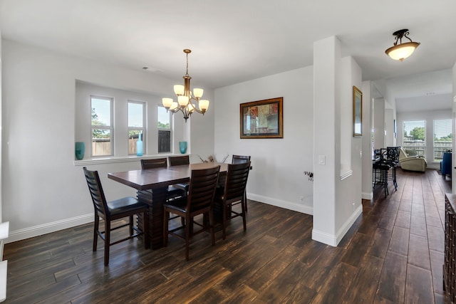 dining space featuring a wealth of natural light, dark hardwood / wood-style flooring, and a chandelier