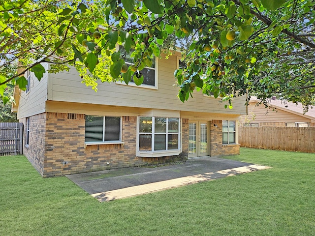 rear view of property featuring a patio area and a lawn