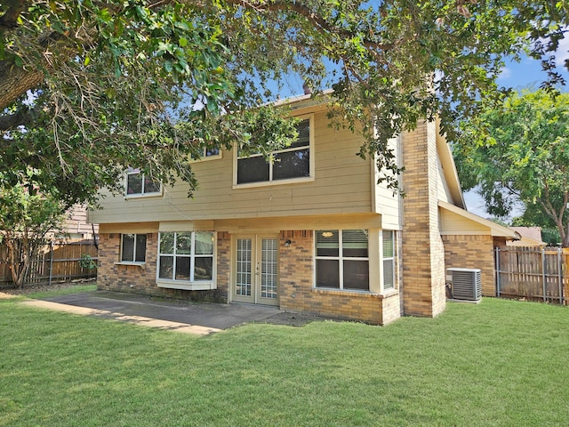 back of property with a lawn and central AC unit