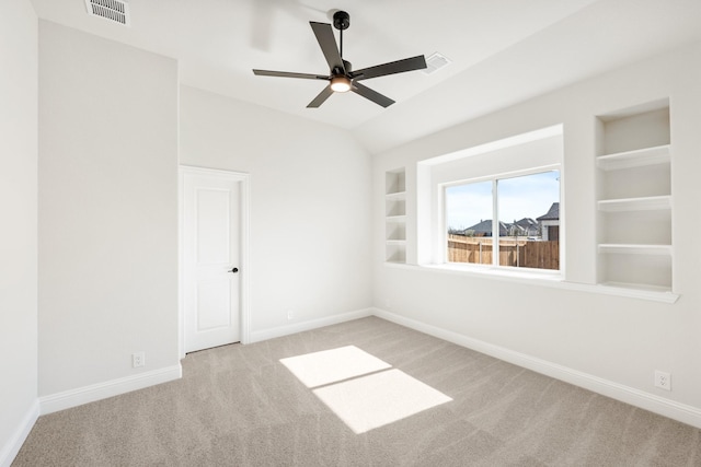 unfurnished room with carpet, baseboards, built in shelves, and visible vents