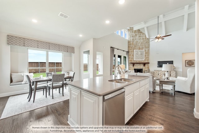 kitchen with dishwasher, sink, a fireplace, a kitchen island with sink, and dark wood-type flooring