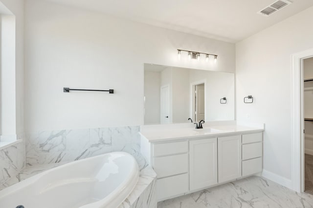 full bathroom with visible vents, marble finish floor, a garden tub, a spacious closet, and vanity