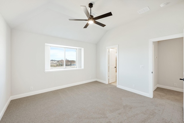 unfurnished bedroom featuring carpet flooring, vaulted ceiling, visible vents, and baseboards