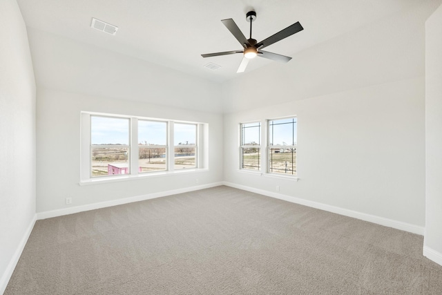 carpeted spare room featuring a ceiling fan, visible vents, and baseboards