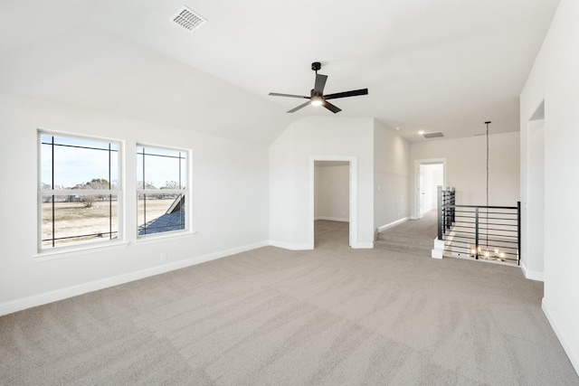 carpeted spare room with lofted ceiling, ceiling fan, visible vents, and baseboards