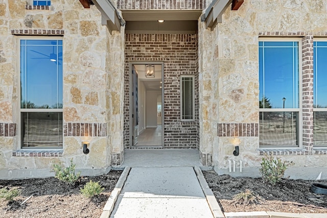 entrance to property featuring stone siding and brick siding