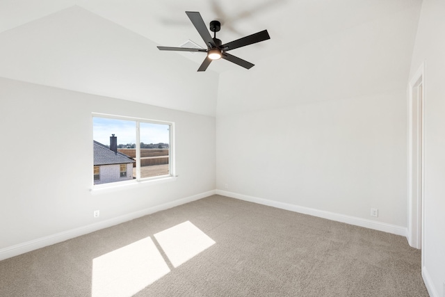 spare room featuring carpet floors, baseboards, a ceiling fan, and lofted ceiling