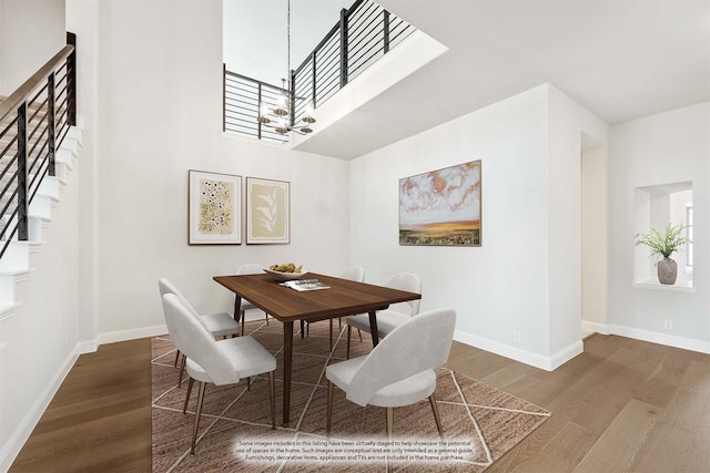 dining space featuring a chandelier, stairway, baseboards, and wood finished floors