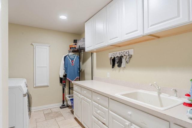 clothes washing area featuring sink, cabinets, and independent washer and dryer