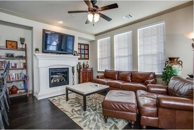 living room featuring ceiling fan, ornamental molding, and dark hardwood / wood-style floors