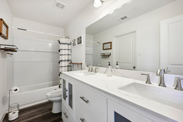 full bathroom featuring toilet, shower / bath combo with shower curtain, hardwood / wood-style floors, and dual bowl vanity