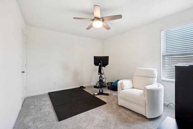 workout room featuring ceiling fan and light colored carpet