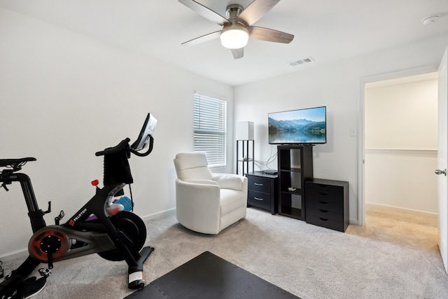 exercise area featuring ceiling fan and light colored carpet