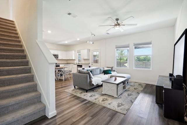 living room featuring ceiling fan and dark hardwood / wood-style flooring