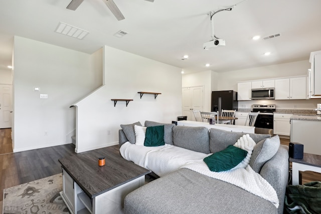 living room with ceiling fan and dark wood-type flooring