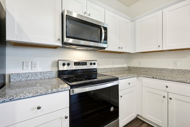 kitchen featuring white cabinetry, light stone countertops, stainless steel appliances, and dark hardwood / wood-style flooring