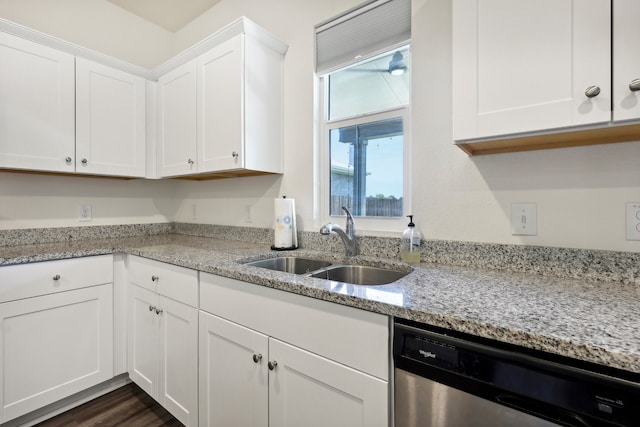 kitchen with white cabinetry, stainless steel dishwasher, dark hardwood / wood-style floors, sink, and light stone counters