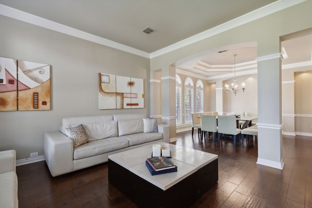 living room with decorative columns, crown molding, dark wood-type flooring, and a notable chandelier