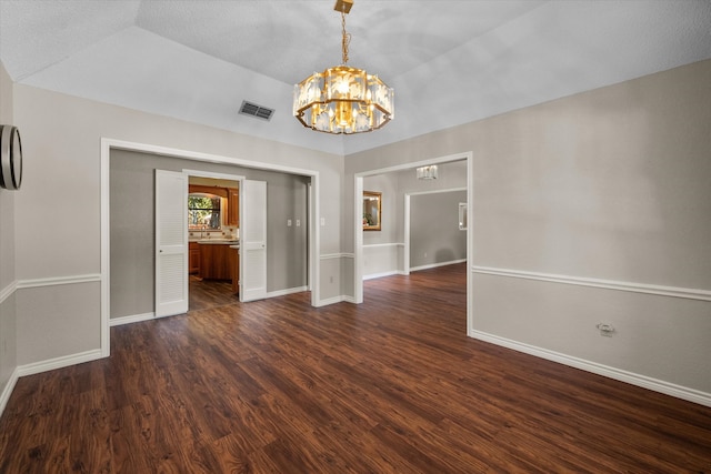 unfurnished dining area with an inviting chandelier, lofted ceiling, and dark wood-type flooring