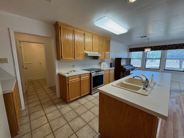 kitchen with light hardwood / wood-style flooring, decorative light fixtures, sink, a textured ceiling, and stainless steel electric stove