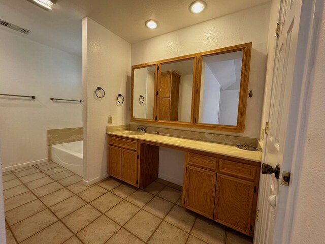 bathroom with tile patterned floors, a bathtub, and vanity