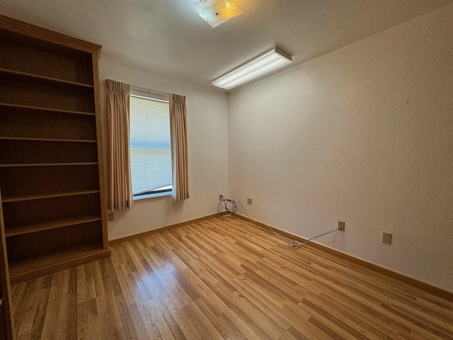 unfurnished room featuring light wood-style floors and baseboards