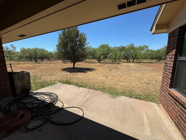 view of patio / terrace with visible vents and a rural view