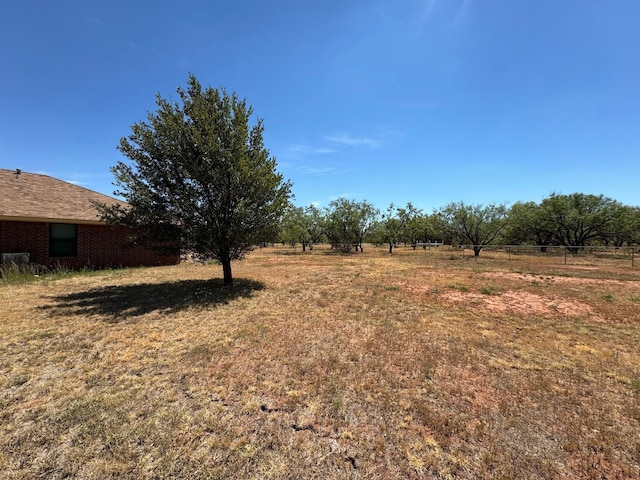 view of yard featuring a rural view and fence