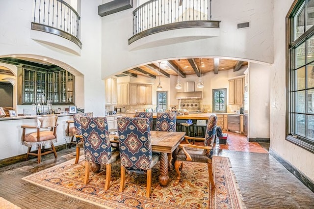 dining room featuring a high ceiling, a wealth of natural light, and beam ceiling