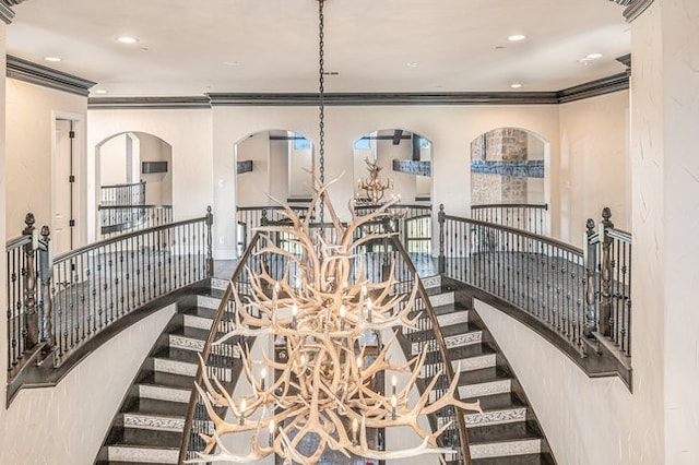 stairs featuring hardwood / wood-style flooring, an inviting chandelier, and ornamental molding