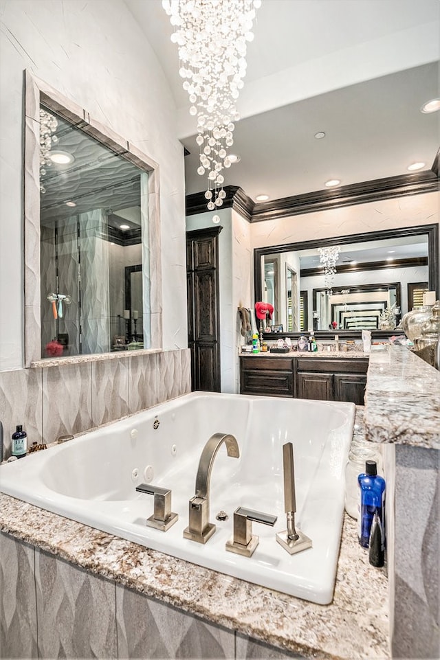 bathroom with tiled bath, vanity, and a chandelier