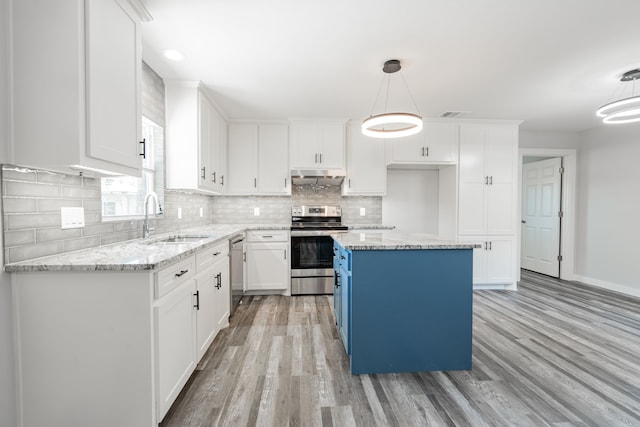 kitchen featuring light hardwood / wood-style flooring, hanging light fixtures, white cabinets, appliances with stainless steel finishes, and sink