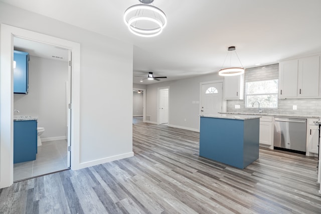 kitchen with ceiling fan, stainless steel dishwasher, light hardwood / wood-style flooring, pendant lighting, and a center island