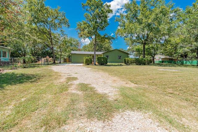 view of yard featuring driveway and fence