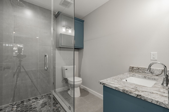 bathroom with toilet, vanity, walk in shower, and tile patterned floors