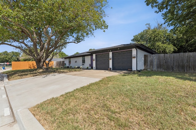 single story home featuring a front yard and a garage