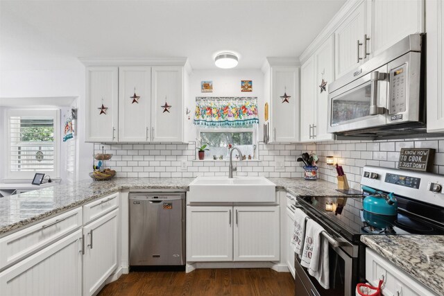 kitchen featuring sink, white cabinetry, appliances with stainless steel finishes, and dark hardwood / wood-style floors