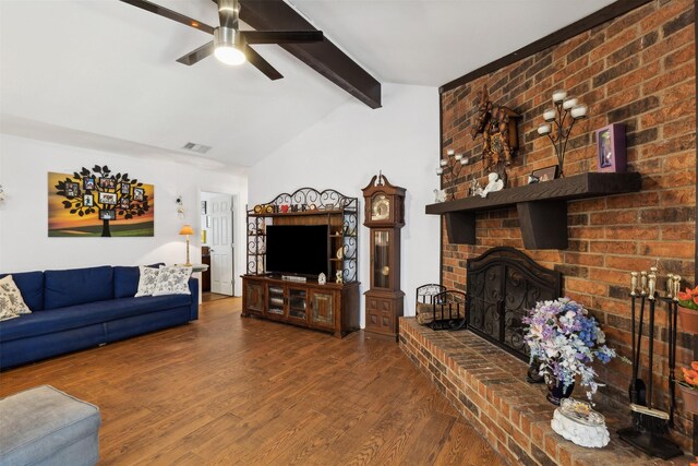 living room with ceiling fan, brick wall, wood-type flooring, a fireplace, and lofted ceiling with beams