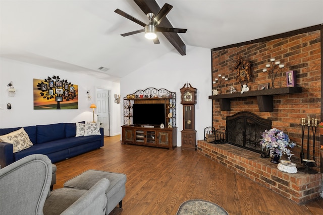 living room featuring hardwood / wood-style floors, lofted ceiling with beams, brick wall, a fireplace, and ceiling fan