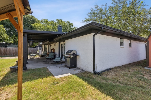 view of home's exterior with a lawn and a patio